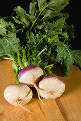 A bunch of Turnips on a wood cutting board