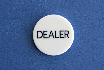 The white dealer button of a poker game