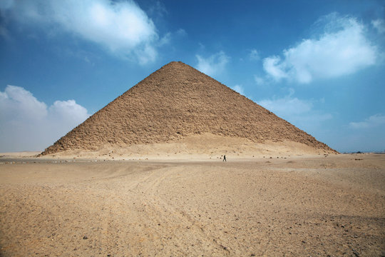 a man walking next red pyramid in egypt