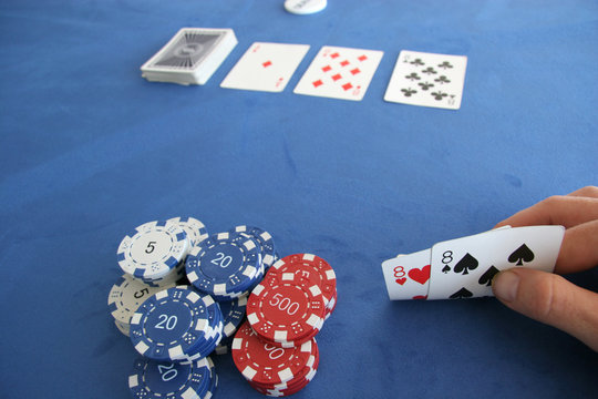 A poker player holds a pair of eights in his hand
