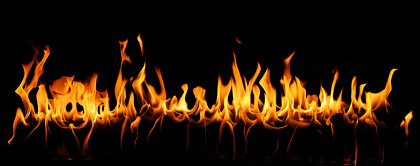 Tongues of fire in a panoramic view over a black background.