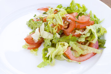 Salad from tomatoes and fresh lettuce with green