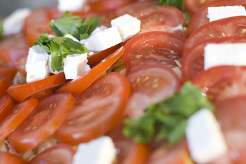 Light snack from tomatoes with soft cheese and green