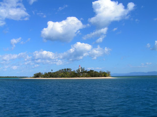 Coral island in a ble sea whith blue sky and white couds behind