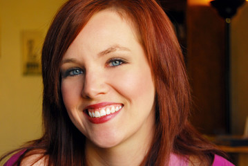 Portrait of young beautiful woman smiling with dark background