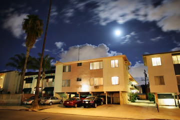 Residential street with apartment buildings at night in LA