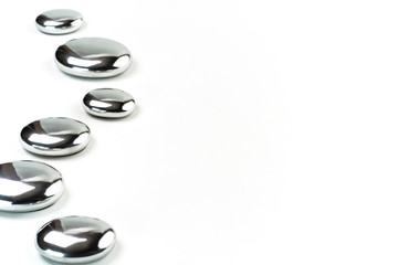 Six metal pebbles on white background.