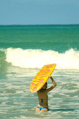 Junge Frau mit boogie board im Wasser
