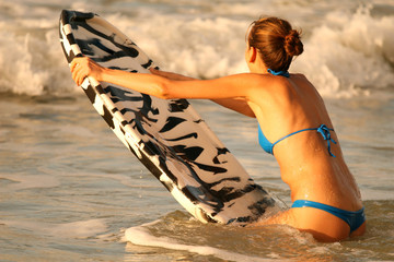 Junge Frau mit boogie board im Wasser