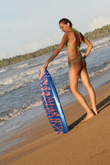 Junge Frau mit boogie board bei Sonnenuntergang
