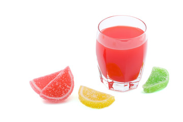 glass of red juice and colorfull fruit jellies isolated