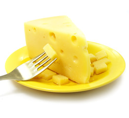 Piece of cheese on the plate with fork isolated over white 