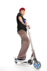 A boy stands by a scooter -    Focus on foreground. 