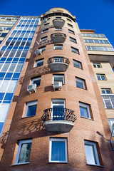 Fototapeta na wymiar Modern building from a brick. Glass balconies.