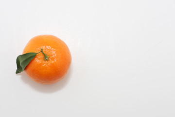 A mandarin fruit shot from above, green leave on 