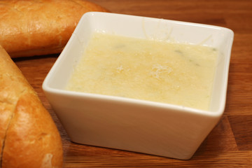cream of broccoli soup in a bowl, bread on the side