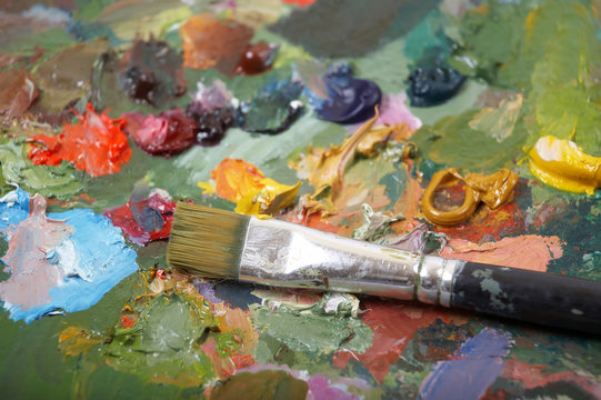 Paintbrush on colorful painting palette. Shallow DOF..