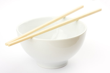 Chopsticks on a white bowl against a white tablecloth