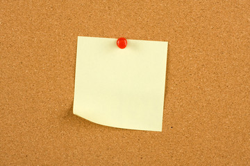 Yellow post-it note on a notcie board - blank for your message