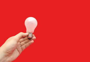 Background with lit lightbulb. Isolated on red
