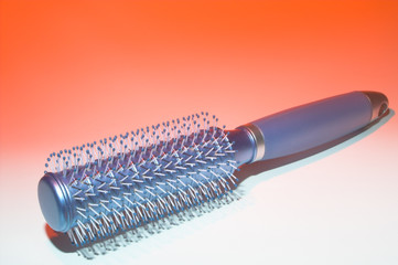 A hairbrush ready to beautify a woman's hair.