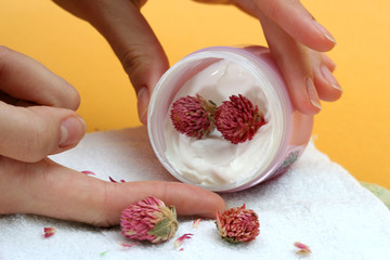 Spa essentials (cream, white towel and flowers) 