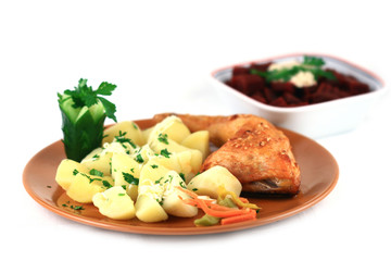 close up of a roasted chicken with potatoes arranged in a plate