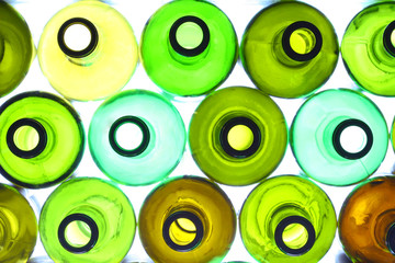 close-up of stack of various wine bottles, backlited