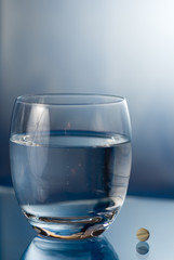 Eine Tablette und ein Glas Wasser