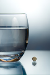 Eine Tablette und ein Glas Wasser
