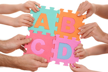 hands holding puzzle with ABCD letters isolated on white