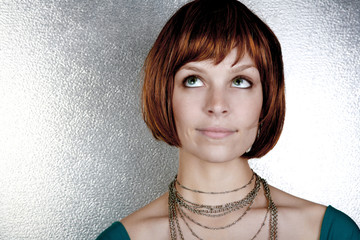 Sassy red head with a cute bob haircut on steel backdrop