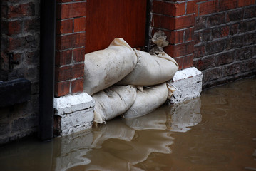 Sandbag barrier in doorway of flooded street in York. - 5968983