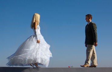 Bride and fiance on blue sky background