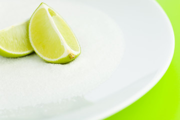 Lime halves top of the sugar on the plate