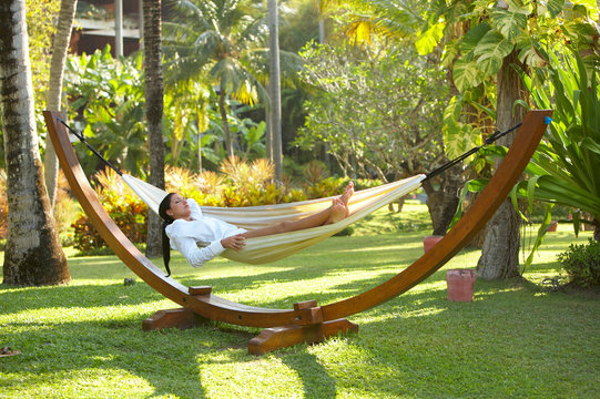 Woman relaxing on hammock at exotic surrounding 