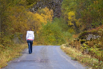 Obraz premium woman walking alone in forest in autumn