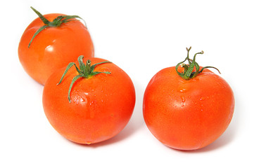 Three ripe red tomatos with green ends isolated on white