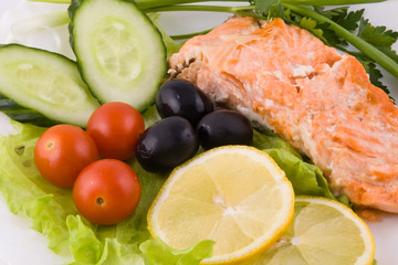 Stake from a trout with vegetables and lemon close up