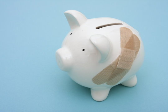 Piggy bank with adhesive bandage with copy space
