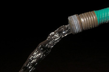 Water spewing from a garden hose. Conservation Concept.