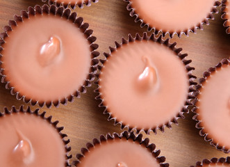 Close up view of peanut butter cups on a wood counter top.