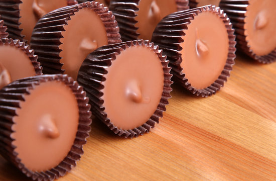 Close up view of peanut butter cups on a wood counter top.
