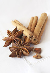 Star anise and cinnamon sticks, on a beige linen napkin.