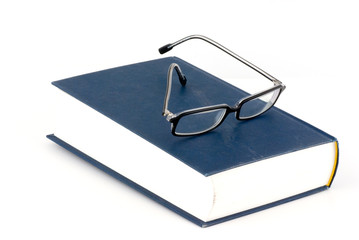 a book and a pair of glasses isolated on white