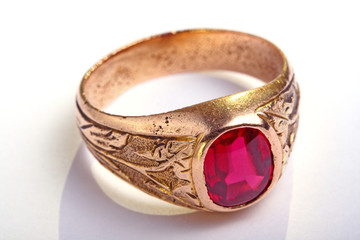 Antic golden ring with ruby cabochon on white.