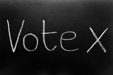 Vote and a cross written on a blackboard.