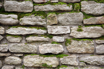 Old wall from a stone covered by a moss