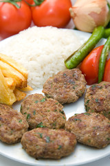 meat balls with french fries and rice on white