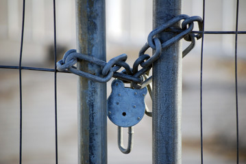 Padlock and chain on building site gate